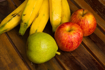 Colorful fresh summer fruits on brown wooden background, healthy organic food on table, detox vitamin nutrition for health care, top close up view, copy space