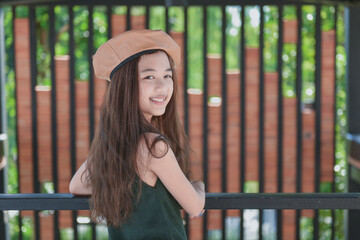 Portrait of  fashion asian  child girl . Wear a sleeveless shirt and brown hat.