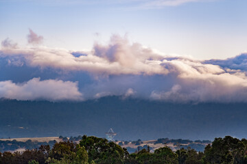Sunset view of a blanket of clouds covering the forests of Santa Cruz Mountains, Stanford Dish visible in the foreground; San Francisco Bay Area, California