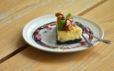 Butter milk cake in white plate putting on wooden desk with decor with petal flowers for beautiful decoration and make to promote and serve for invite to customer join to service.