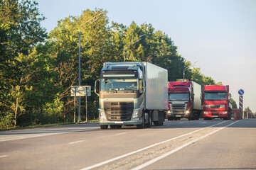 Fototapeta na wymiar Trucks moving along a suburban highway