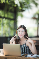 Portrait of an Asian woman wearing a face shield to protect her face to prevent the spread of the coronavirus, healthcare new normal lifestyle and social distancing concept