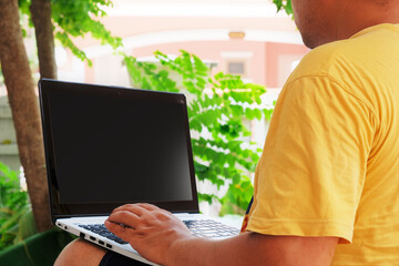 man working at home on a laptop in the garden