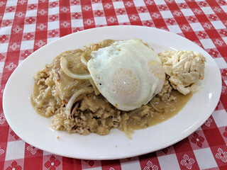 Braddha Moco featuring corn beef hash on top of rice covered in gravy with two eggs over easy