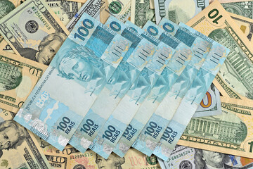 Notas de 100 reais junto com dólares americanos de diversos valores