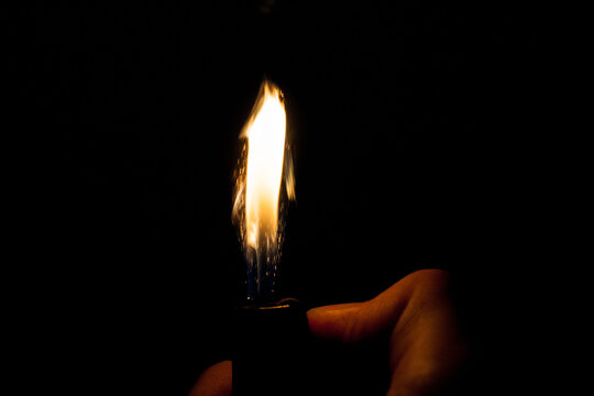Close up view of real sparking light from lighter in dark black background