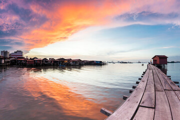 Fototapeta premium Wooden bridge Clan Tan Jetty view during sunrise in George Town, Penang