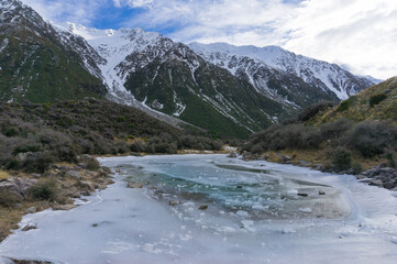 Winter mountain landscape with ice frozen lake and snow covered mountains