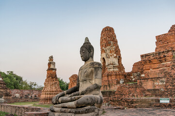 Ruins of old Thai temple with sitting Buddha statue