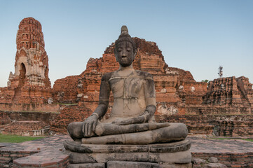 Ruins of old Thai temple with sitting Buddha statue