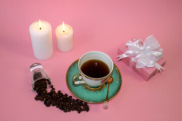 .coffee, flowers, candles on a pink background as a symbol of home warmth and coziness, beauty and a wonderful morning breakfast