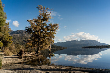 Lake landscape with mountain hills and reflection in still water