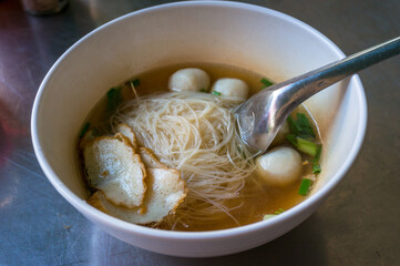 Bowl of asian soup with fish balls, tofu and noodles