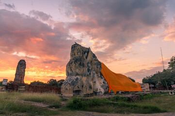 Sunrise scene with ruins of Reclining Buddha decorated with orange cloth