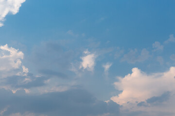 
Beautiful dramatic gray and white clouds on blue sky, variety of shapes, silhouettes and shades at sunset time