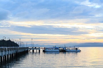 Fototapeta na wymiar Boat resting near a jetty with sunrise background