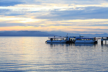 Boat resting near a jetty with sunrise background