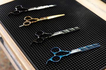 Fototapeta na wymiar Vintage barber shop scissors on black pad,Vintage hairdresser work space