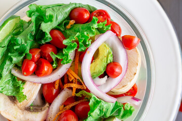 cherry tomato salad, with mushrooms, onion on a black table, with some patterns