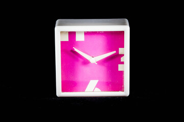 Pink rectangle clock in a black isolated background