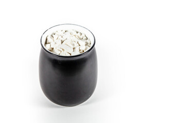 white powder in a black pot in a white isolated background