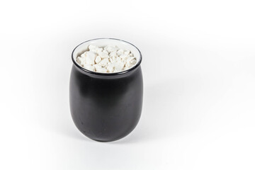 white powder in a black pot in a white isolated background