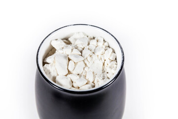white powder in a black pot in a white isolated background