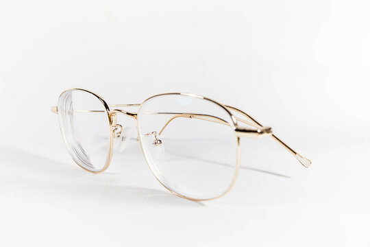 Gold frame spectacles glasses in a white isolated background