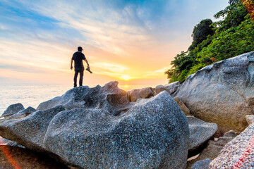 Silhouette view of male model photographer by sunrise or sunset background
