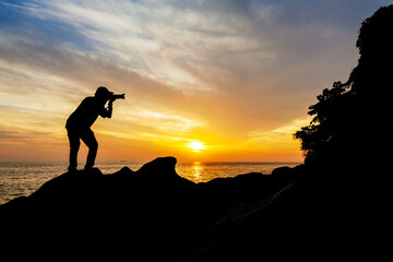 Silhouette view of male model photographer by sunrise or sunset background
