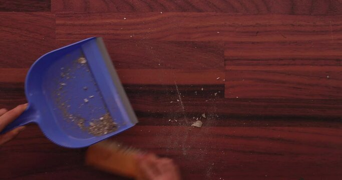 Scooping dirt into a dustpan