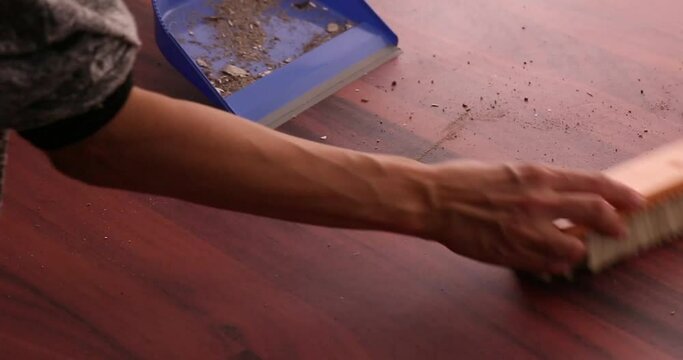 Scooping dirt into a dustpan