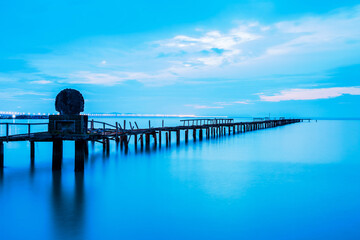Long exposure view of wooden bridge in blue background