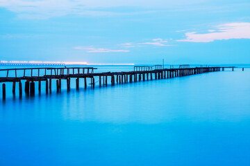 Fototapeta na wymiar Long exposure view of wooden bridge in blue background