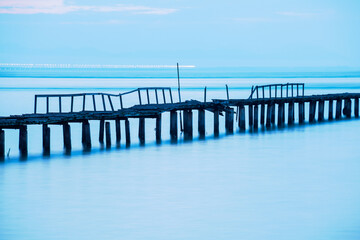 Obraz premium Long exposure view of wooden bridge in blue background