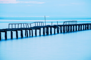 Long exposure view of wooden bridge in blue background