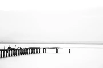 Selbstklebende Fototapete Schwarz und weiss Langzeitbelichtung der Holzbrücke im Rücken und weißem Hintergrund