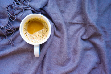 A cup of coffee in gray scarf. Morning coffee drink. Flat lay concept.