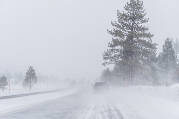 Obraz premium Travel on a snowy mountain road snowstorm