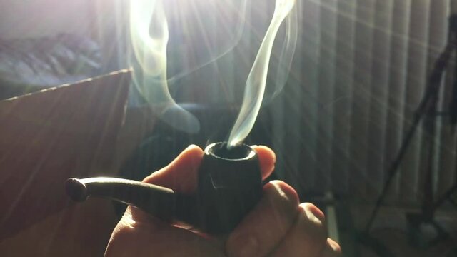 Close up shot of a smoldering pipe load of whatever your imagination desires for this type of thing. Really it's a fat bowl of amazing chronic weed from California USA in the height of a Pandemic