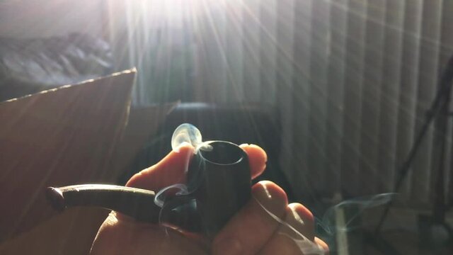 Close up shot of a smoldering pipe load of whatever your imagination desires for this type of thing. Really it's a fat bowl of amazing chronic weed from California USA in the height of a Pandemic