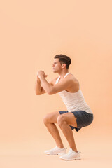 Sporty young man training on color background