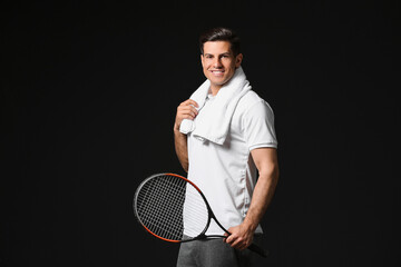Sporty male tennis player on dark background