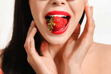 Sexy young woman with strawberry on white background