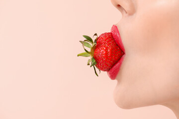 Sexy young woman with strawberry in mouth on light background, closeup
