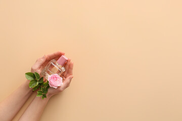 Female hands with floral perfume on color background