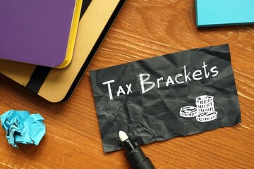 Business concept meaning Tax Brackets with phrase on the piece of paper.