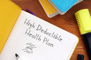 Business concept about high deductible health plan with sign on the piece of paper.