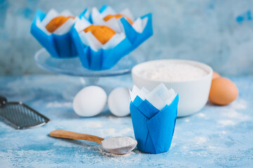 Muffin baking cup with flour on color background