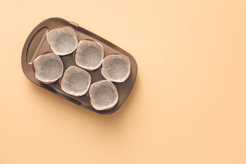 Muffin baking cups with tray on color background